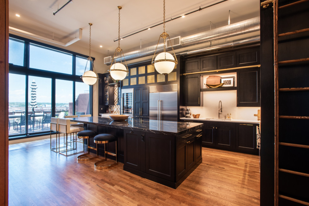 Design ideas for a medium sized urban open plan kitchen in Denver with black cabinets, white splashback, stainless steel appliances, an island and black worktops.