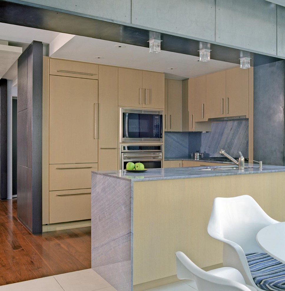 Пример оригинального дизайна: п-образная кухня в современном стиле с плоскими фасадами, бежевыми фасадами, мраморной столешницей, синим фартуком, фартуком из каменной плиты, техникой под мебельный фасад и обеденным столом