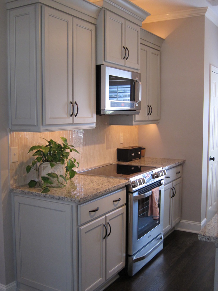 Example of a small eclectic l-shaped dark wood floor eat-in kitchen design in Other with a farmhouse sink, flat-panel cabinets, green cabinets, granite countertops, beige backsplash, matchstick tile backsplash, white appliances and a peninsula
