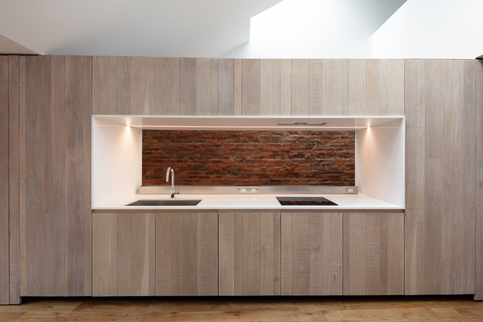 Inspiration for a medium sized urban single-wall open plan kitchen in Other with a submerged sink, flat-panel cabinets, light wood cabinets, engineered stone countertops, integrated appliances, light hardwood flooring, no island, yellow floors and white worktops.