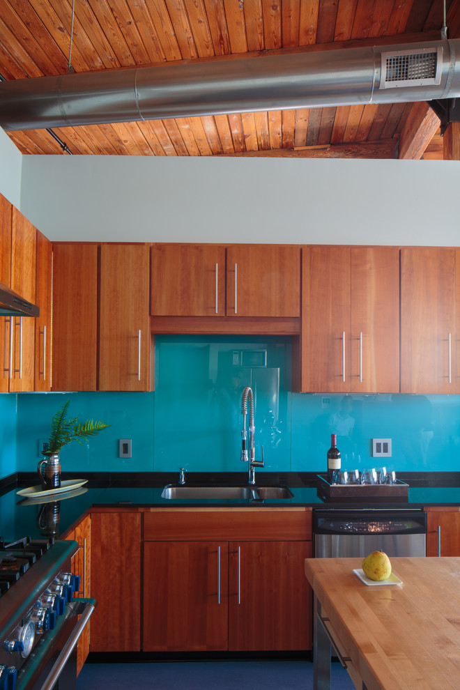 Ejemplo de cocina contemporánea con fregadero de doble seno, armarios con paneles lisos, puertas de armario de madera oscura y salpicadero azul