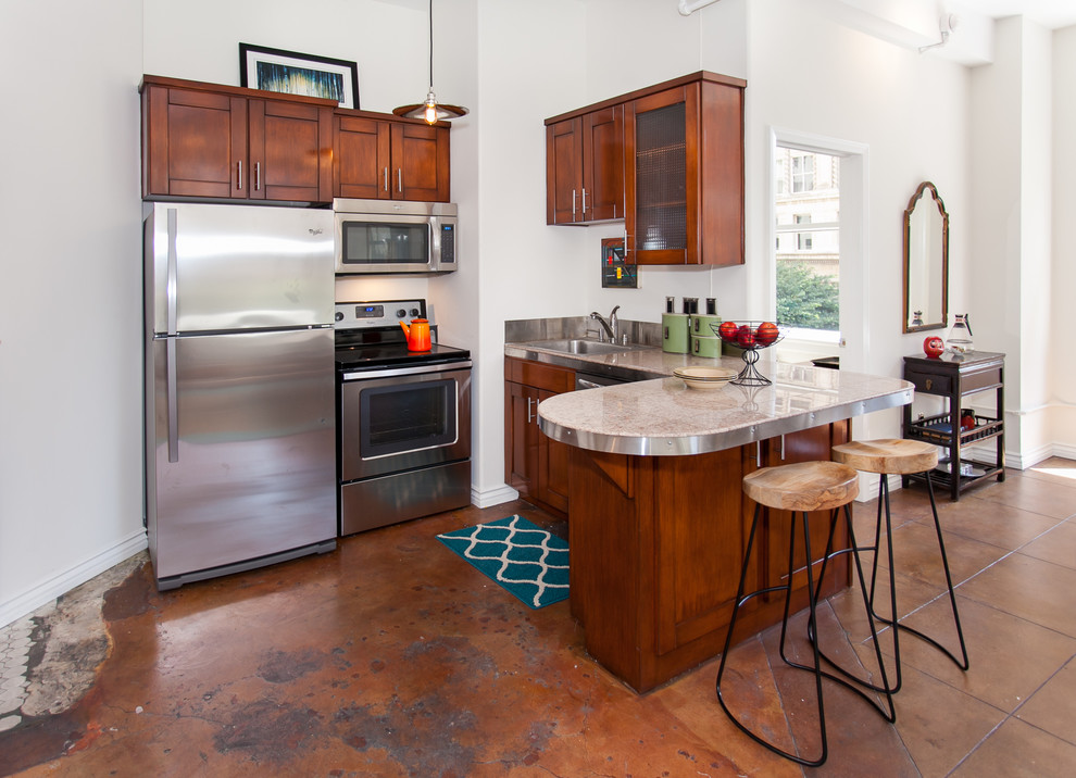 ロサンゼルスにある低価格の小さなおしゃれなキッチン (濃色木目調キャビネット、シルバーの調理設備) の写真