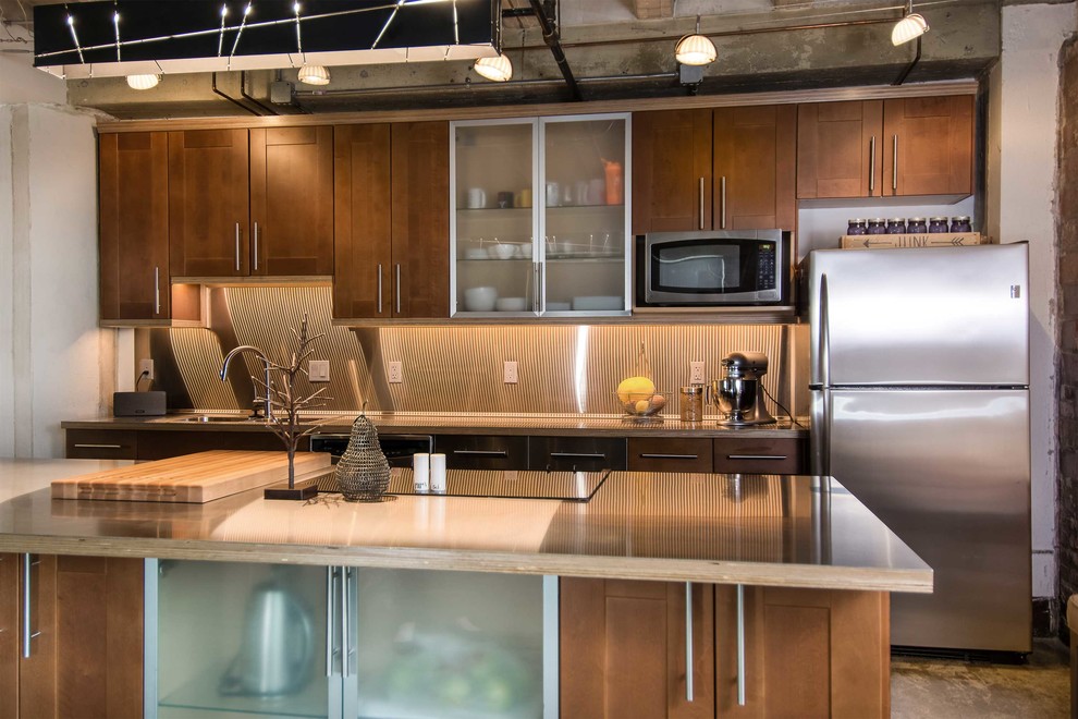 Foto de cocina comedor lineal contemporánea con puertas de armario de madera oscura, electrodomésticos de acero inoxidable, suelo de cemento y una isla