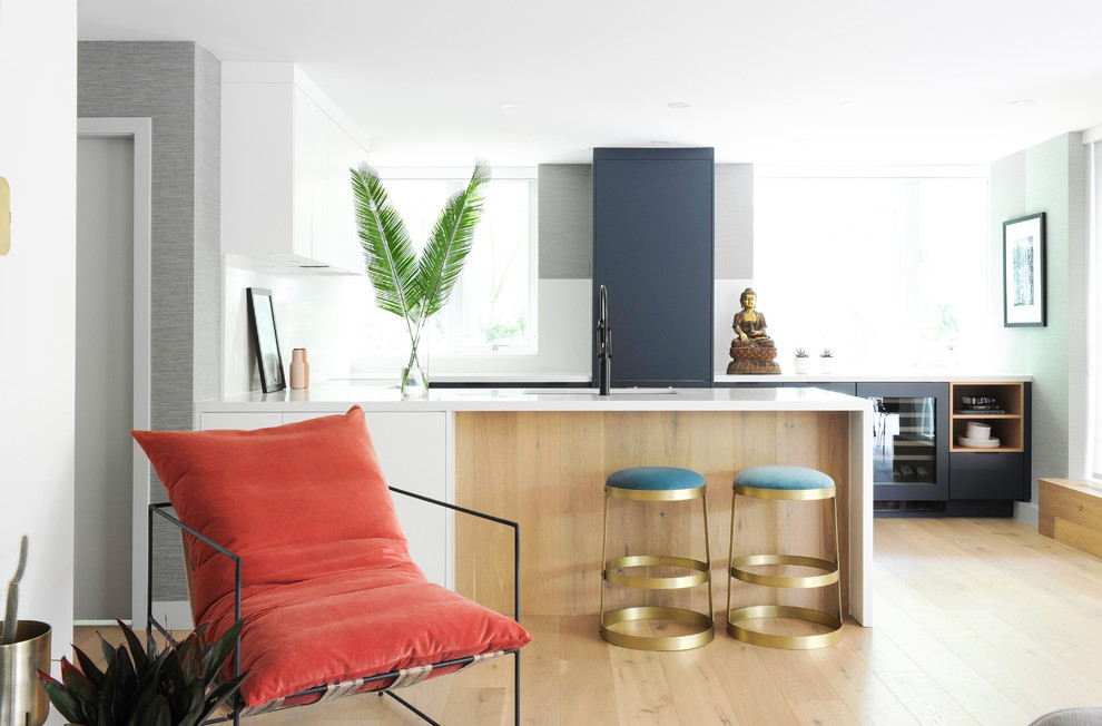 This is an example of a small eclectic l-shaped open plan kitchen in Other with a submerged sink, flat-panel cabinets, light hardwood flooring, a breakfast bar, beige floors, white worktops, white cabinets, quartz worktops and integrated appliances.