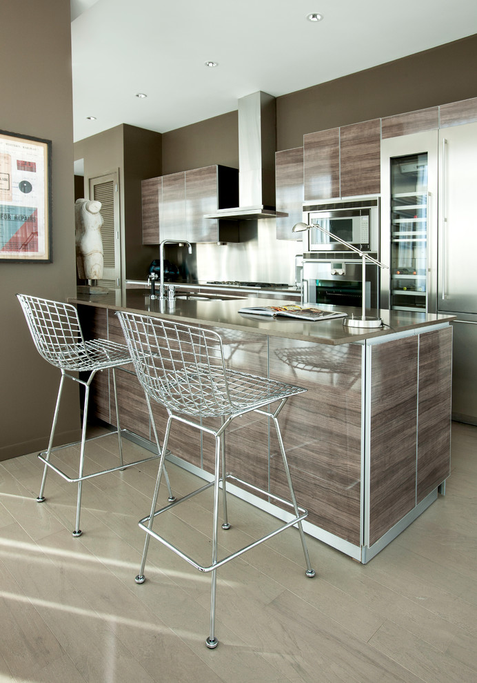 Exemple d'une cuisine parallèle tendance en bois brun de taille moyenne avec un placard à porte plane, un électroménager en acier inoxydable, un sol en carrelage de porcelaine et îlot.