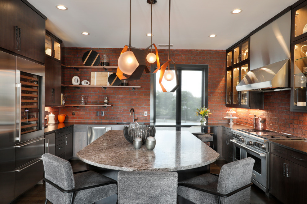 Kitchen - industrial u-shaped dark wood floor kitchen idea in Other with dark wood cabinets, brick backsplash, stainless steel appliances, an island, an integrated sink, glass-front cabinets, stainless steel countertops and red backsplash