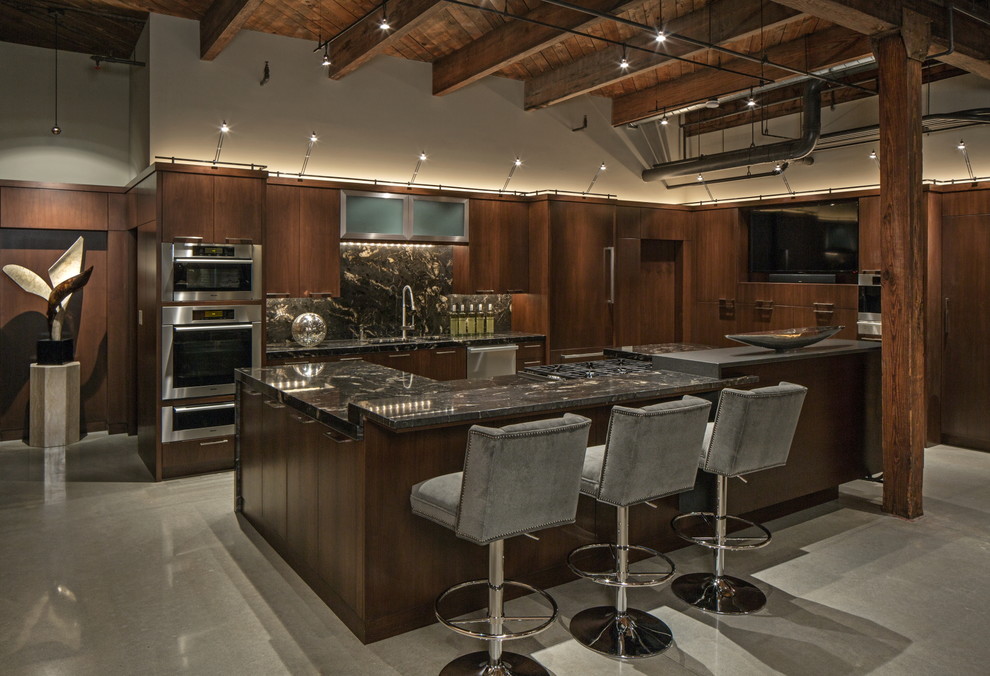 オマハにあるインダストリアルスタイルのおしゃれなアイランドキッチン (濃色木目調キャビネット、マルチカラーのキッチンパネル、シルバーの調理設備、コンクリートの床) の写真
