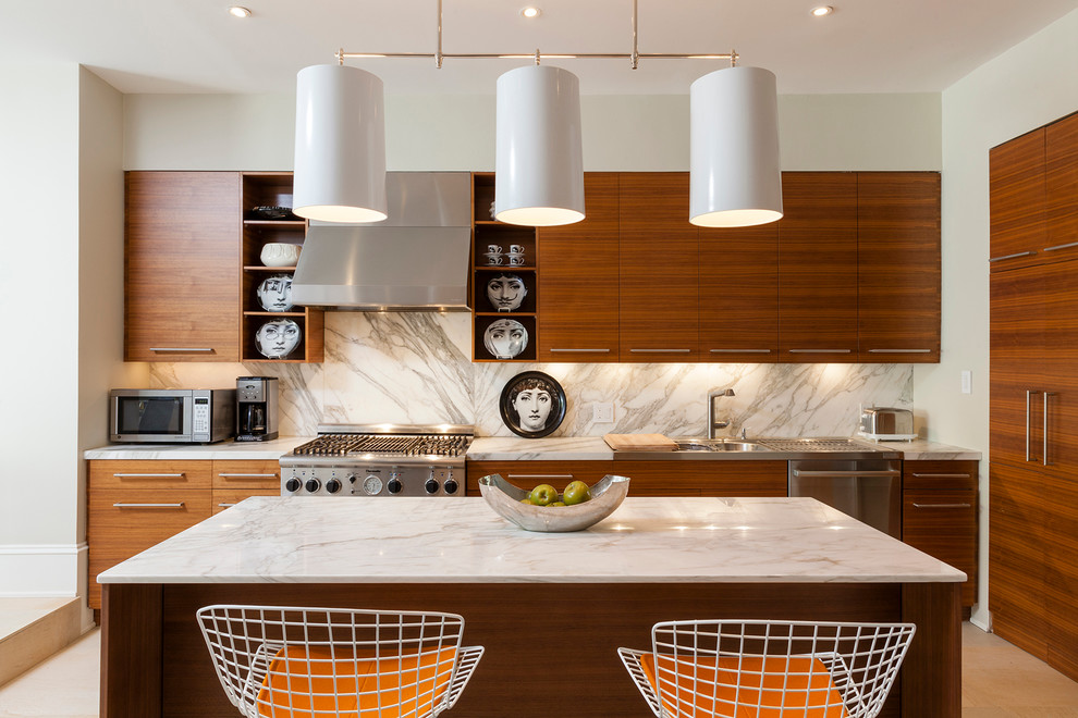 ニューヨークにあるコンテンポラリースタイルのおしゃれなアイランドキッチン (ダブルシンク、フラットパネル扉のキャビネット、中間色木目調キャビネット、白いキッチンパネル、シルバーの調理設備) の写真