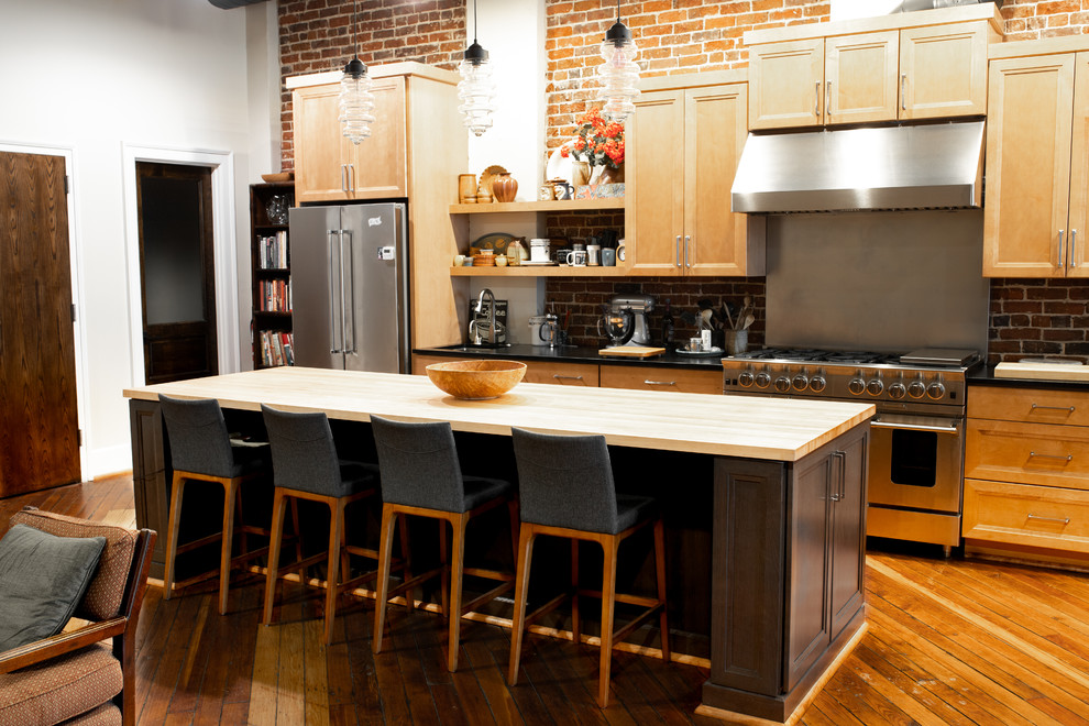Idéer för ett mellanstort klassiskt svart linjärt kök och matrum, med en undermonterad diskho, luckor med infälld panel, skåp i mellenmörkt trä, bänkskiva i täljsten, rött stänkskydd, stänkskydd i tegel, rostfria vitvaror, mellanmörkt trägolv, en köksö och brunt golv