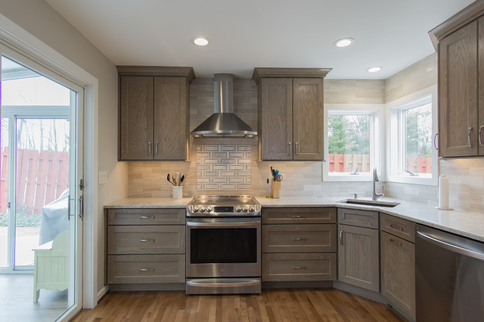 Large transitional l-shaped medium tone wood floor and brown floor eat-in kitchen photo in Philadelphia with a drop-in sink, shaker cabinets, beige cabinets, quartz countertops, beige backsplash, slate backsplash, stainless steel appliances, no island and white countertops