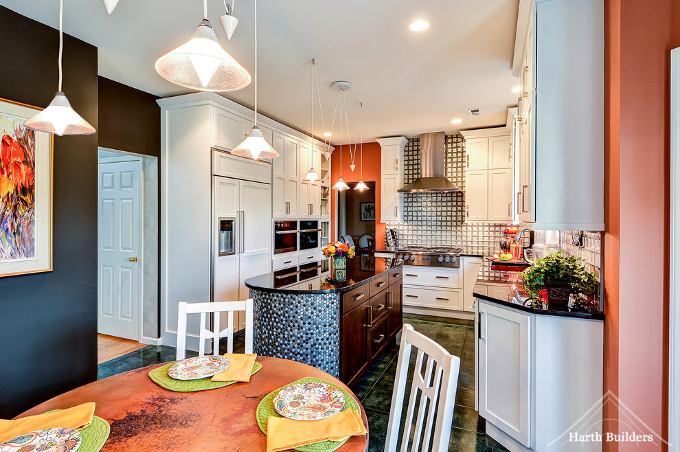 Foto på ett mellanstort eklektiskt kök, med en undermonterad diskho, skåp i shakerstil, vita skåp, granitbänkskiva, grått stänkskydd, stänkskydd i glaskakel, rostfria vitvaror, klinkergolv i keramik och en köksö