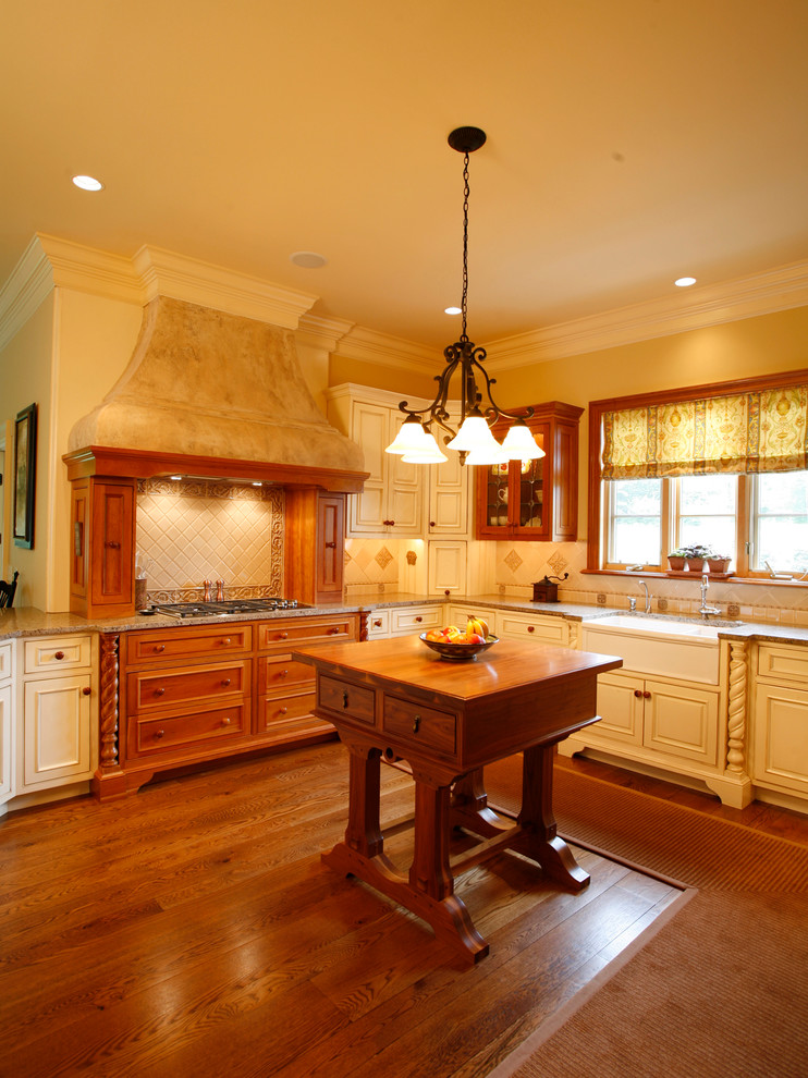 Bild på ett vintage kök med öppen planlösning, med en rustik diskho, granitbänkskiva, beige stänkskydd, stänkskydd i stenkakel, integrerade vitvaror, mellanmörkt trägolv och beige skåp