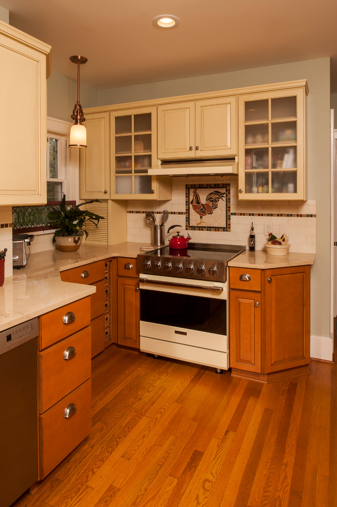 Exempel på ett lantligt kök, med vitt stänkskydd, stänkskydd i tunnelbanekakel, rostfria vitvaror, en rustik diskho, luckor med upphöjd panel, gula skåp, bänkskiva i kalksten, mellanmörkt trägolv och en halv köksö