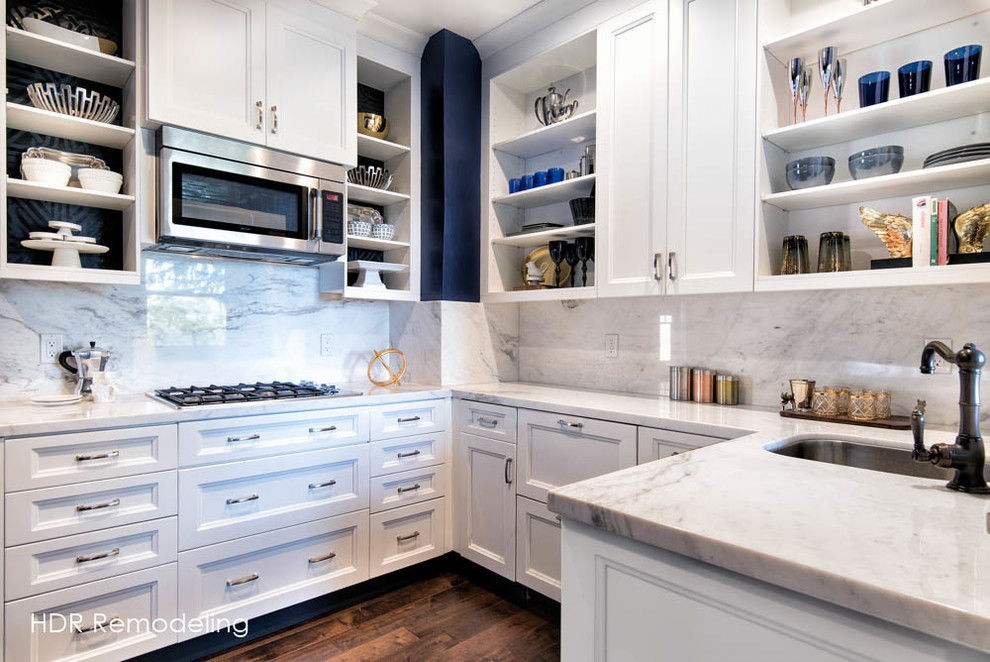 Idée de décoration pour une cuisine minimaliste avec un placard à porte plane, des portes de placard blanches, plan de travail en marbre et une crédence blanche.