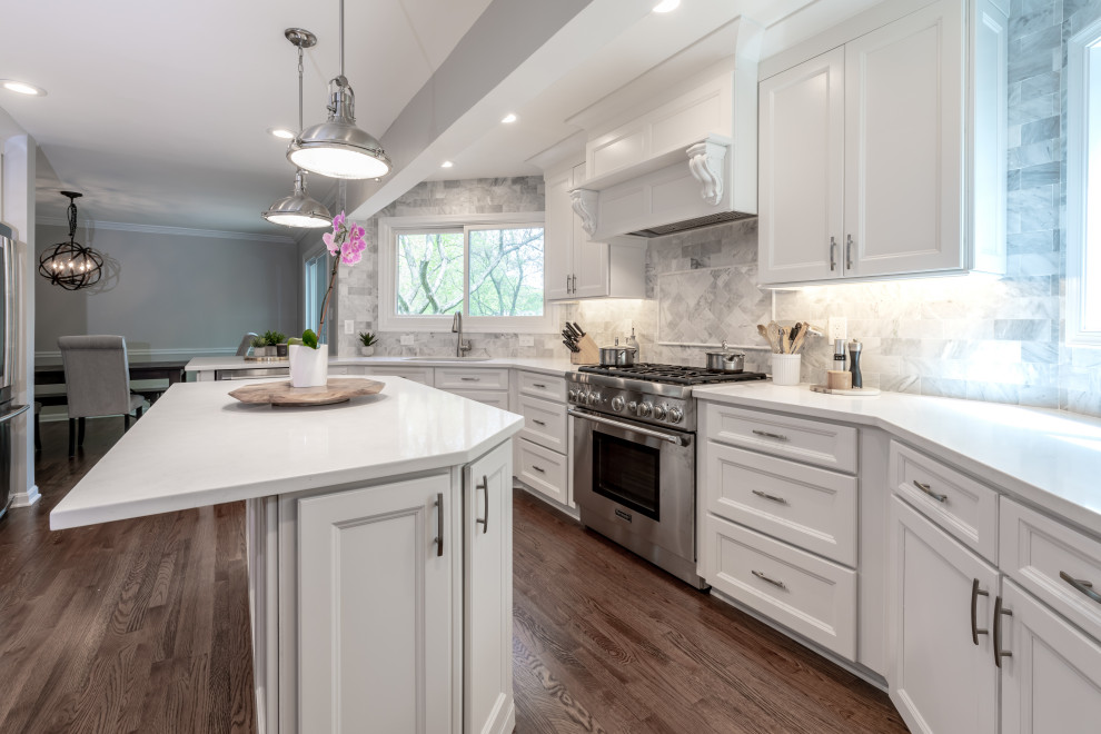 Immagine di una cucina minimal di medie dimensioni con ante bianche, top in granito, paraspruzzi grigio, elettrodomestici in acciaio inossidabile, pavimento marrone e top bianco