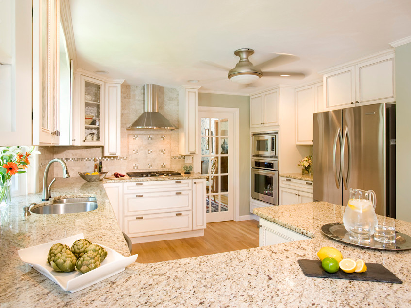 Eat-in kitchen - mid-sized transitional u-shaped light wood floor eat-in kitchen idea in Boston with a double-bowl sink, recessed-panel cabinets, white cabinets, granite countertops, multicolored backsplash, ceramic backsplash, stainless steel appliances and a peninsula