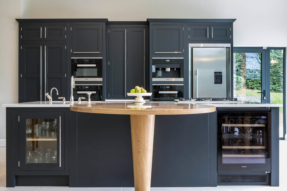 Design ideas for a traditional kitchen in Buckinghamshire with shaker cabinets, black cabinets, black appliances and an island.