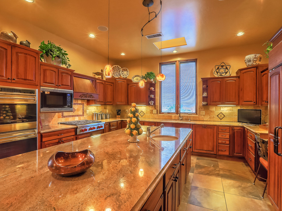 This is an example of a large u-shaped kitchen pantry in Albuquerque with a submerged sink, recessed-panel cabinets, medium wood cabinets, granite worktops, beige splashback, mosaic tiled splashback, stainless steel appliances, travertine flooring, an island and beige floors.