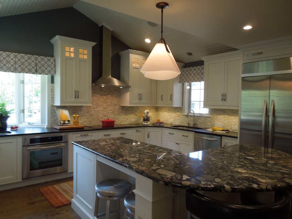 Elegant u-shaped eat-in kitchen photo in Boston with an undermount sink, shaker cabinets, white cabinets, granite countertops, multicolored backsplash and stainless steel appliances