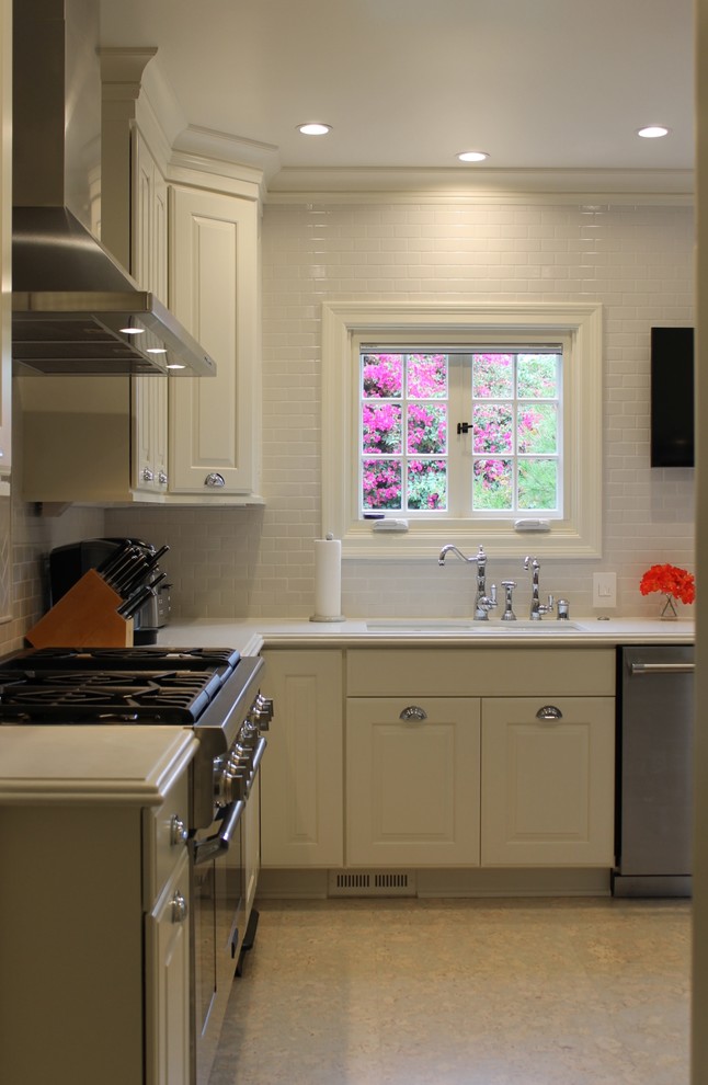 Bild på ett stort vintage kök, med en dubbel diskho, luckor med upphöjd panel, vita skåp, bänkskiva i kvarts, vitt stänkskydd, stänkskydd i keramik, rostfria vitvaror, korkgolv och vitt golv