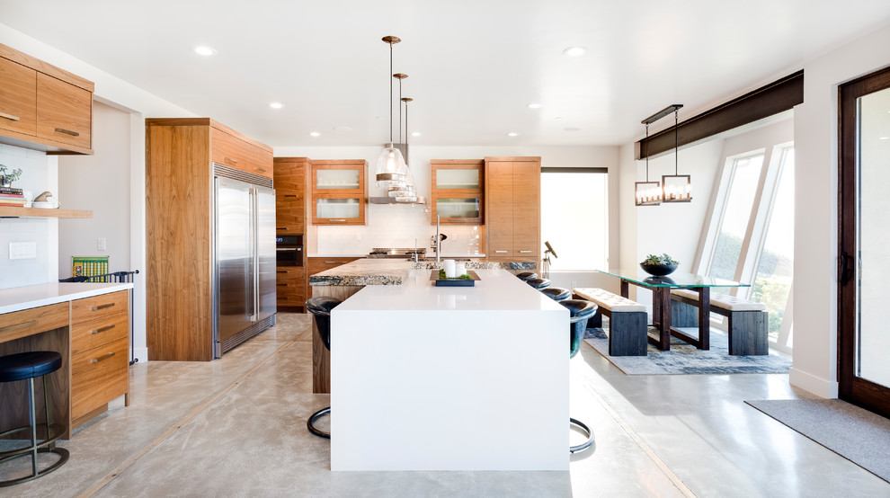Mountain style gray floor eat-in kitchen photo in Salt Lake City with medium tone wood cabinets, white backsplash, stainless steel appliances and an island