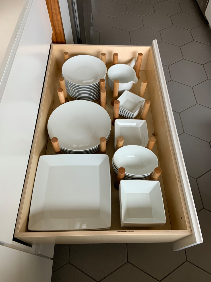 Example of a mid-sized mid-century modern l-shaped porcelain tile, gray floor and vaulted ceiling open concept kitchen design in San Diego with an undermount sink, flat-panel cabinets, white cabinets, quartz countertops, white backsplash, quartz backsplash, stainless steel appliances, an island and white countertops
