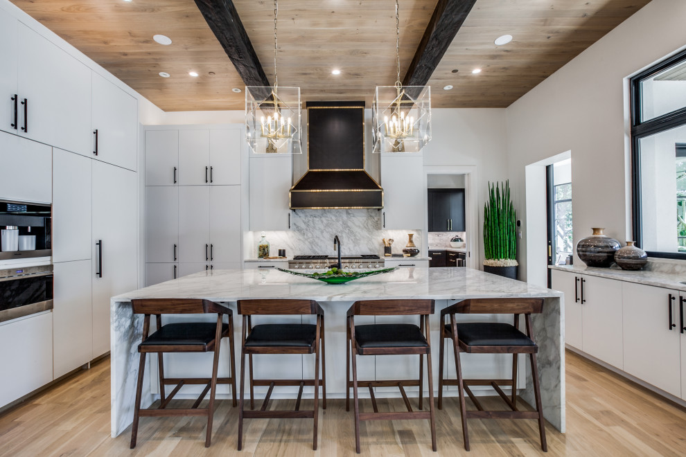 Eat-in kitchen - large mediterranean exposed beam eat-in kitchen idea in Dallas with a drop-in sink, flat-panel cabinets, white cabinets, marble countertops, stainless steel appliances, an island and multicolored countertops