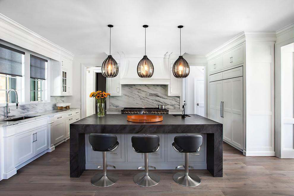 Example of a large transitional u-shaped dark wood floor and brown floor open concept kitchen design in New York with an undermount sink, recessed-panel cabinets, white cabinets, marble countertops, multicolored backsplash, marble backsplash, an island and paneled appliances