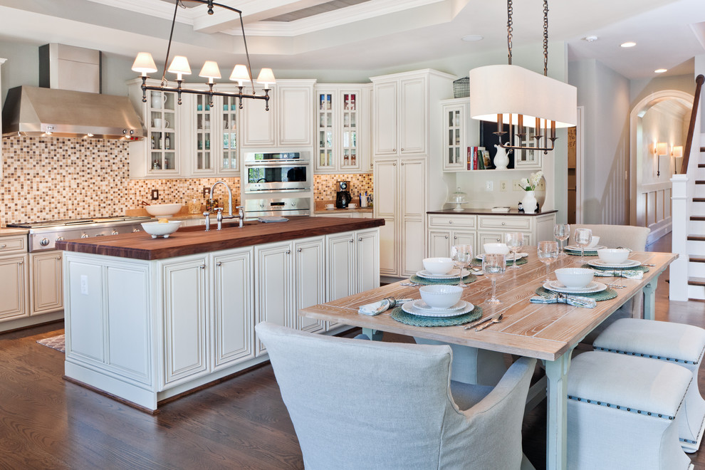 Klassisk inredning av ett kök och matrum, med rostfria vitvaror och träbänkskiva