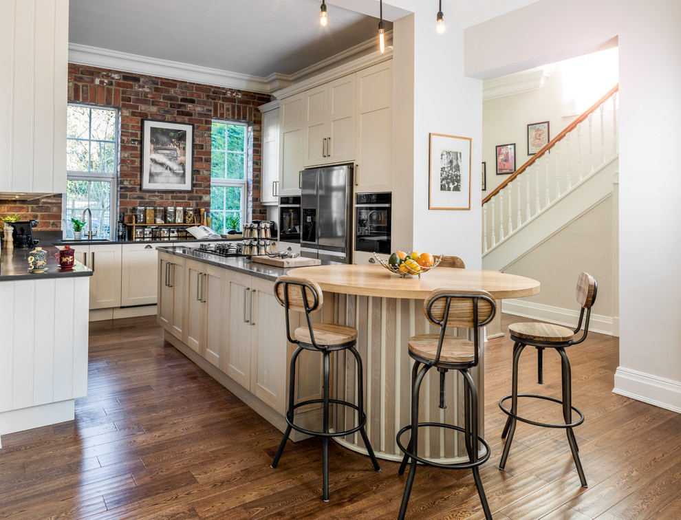 Inspiration for a medium sized farmhouse kitchen in Berkshire with recessed-panel cabinets, beige cabinets, dark hardwood flooring, an island, brown floors, wood worktops and beige worktops.