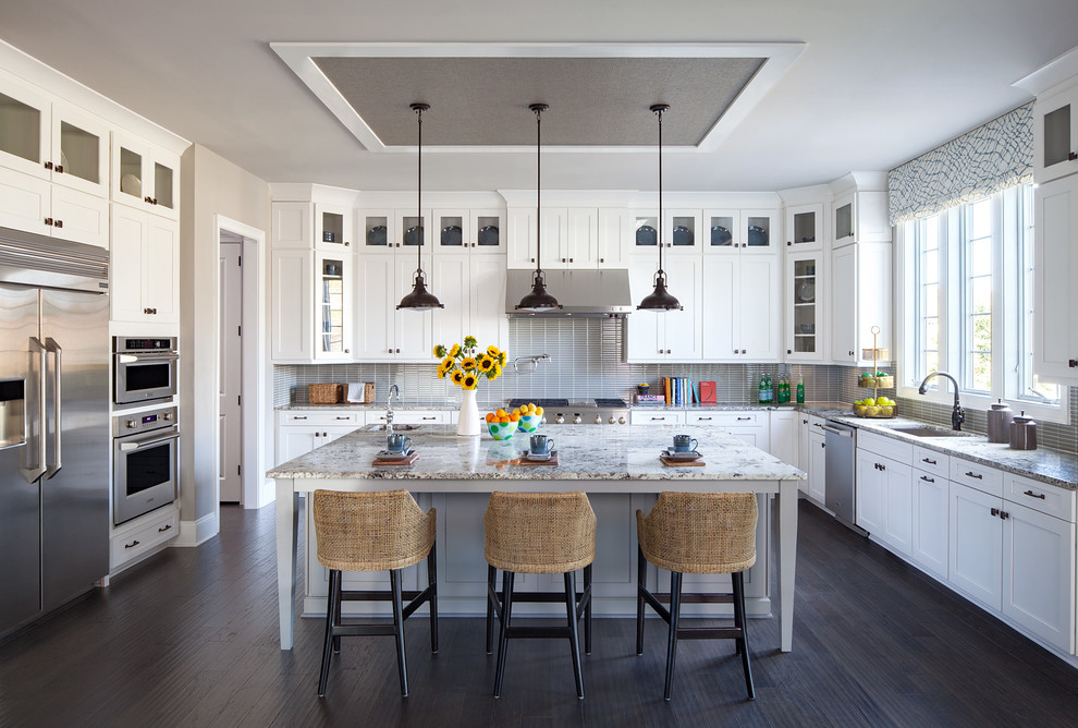 Inspiration for a transitional u-shaped dark wood floor and brown floor open concept kitchen remodel in Philadelphia with an undermount sink, recessed-panel cabinets, white cabinets, gray backsplash, glass tile backsplash, stainless steel appliances and an island