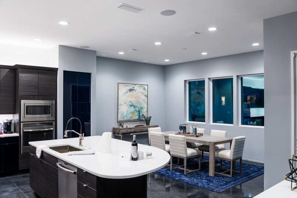 Exempel på ett mellanstort modernt kök, med en undermonterad diskho, släta luckor, blå skåp, bänkskiva i kvarts, vitt stänkskydd, stänkskydd i keramik, rostfria vitvaror, betonggolv, en köksö och grått golv