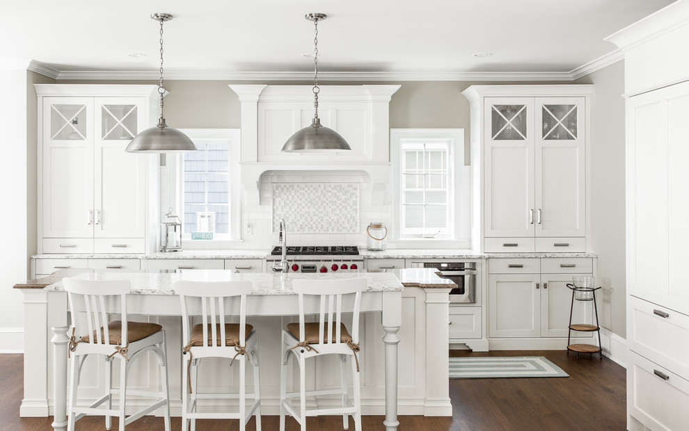 Example of a large classic galley dark wood floor open concept kitchen design in New York with granite countertops, gray backsplash, glass tile backsplash, stainless steel appliances, an island, shaker cabinets and white cabinets