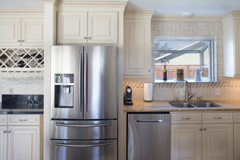 Foto de cocina romántica de tamaño medio con fregadero de doble seno, puertas de armario blancas, electrodomésticos de acero inoxidable y encimera de granito