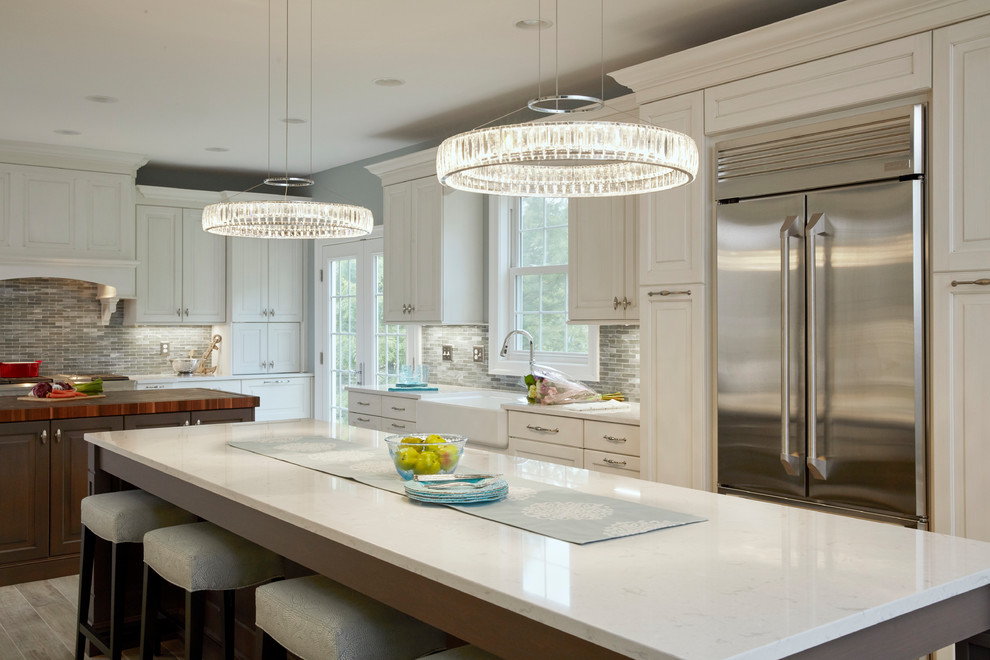 Huge elegant u-shaped porcelain tile and gray floor open concept kitchen photo in Baltimore with a farmhouse sink, raised-panel cabinets, white cabinets, quartz countertops, blue backsplash, mosaic tile backsplash, stainless steel appliances, two islands and white countertops