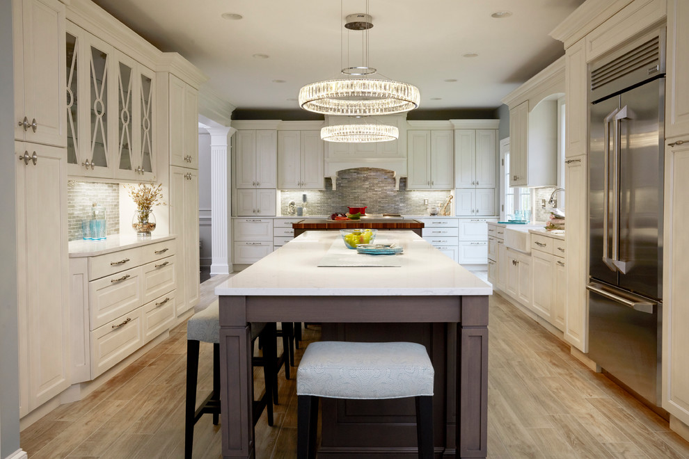 Inspiration for a huge timeless u-shaped porcelain tile and gray floor open concept kitchen remodel in Baltimore with a farmhouse sink, raised-panel cabinets, white cabinets, quartz countertops, blue backsplash, mosaic tile backsplash, stainless steel appliances, two islands and white countertops