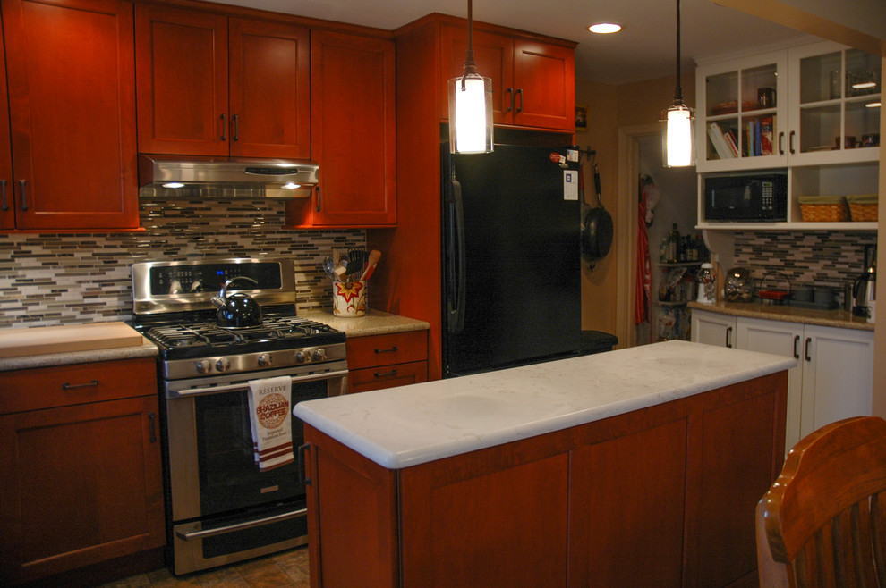 Exempel på ett litet klassiskt kök, med en undermonterad diskho, luckor med infälld panel, skåp i mellenmörkt trä, bänkskiva i kvarts, flerfärgad stänkskydd, stänkskydd i stickkakel, svarta vitvaror, linoleumgolv och en köksö
