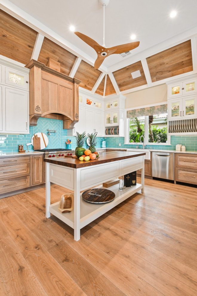 Inspiration for a large tropical u-shaped light wood floor, brown floor and wood ceiling open concept kitchen remodel in Other with an undermount sink, beaded inset cabinets, white cabinets, quartzite countertops, blue backsplash, glass tile backsplash, stainless steel appliances, two islands and beige countertops