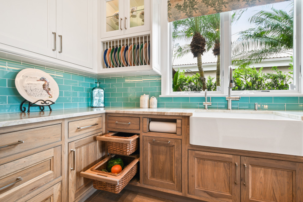 Foto på ett stort tropiskt beige kök, med en undermonterad diskho, luckor med profilerade fronter, vita skåp, bänkskiva i kvartsit, blått stänkskydd, stänkskydd i glaskakel, rostfria vitvaror, ljust trägolv, flera köksöar och brunt golv