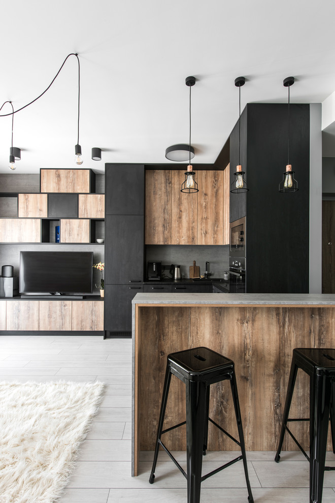 Medium sized contemporary l-shaped open plan kitchen in Lyon with flat-panel cabinets, black cabinets, grey splashback, integrated appliances, a breakfast bar and grey floors.