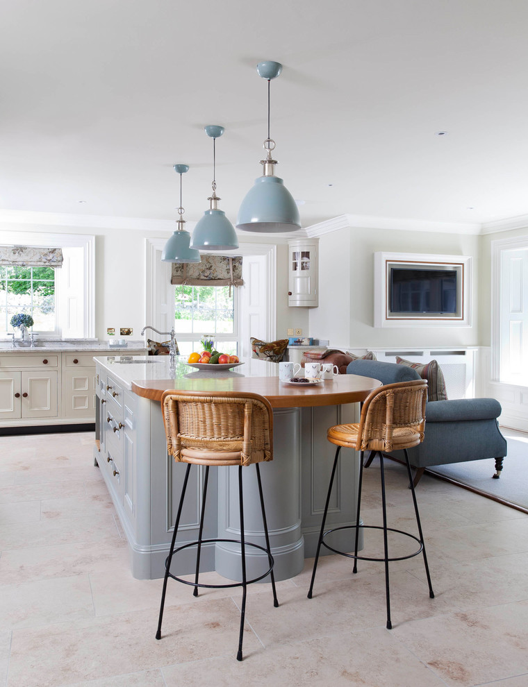 This is an example of a large country l-shaped open plan kitchen in Belfast with a submerged sink, beaded cabinets, blue cabinets, quartz worktops, white splashback, ceramic splashback, integrated appliances, ceramic flooring, an island and grey floors.