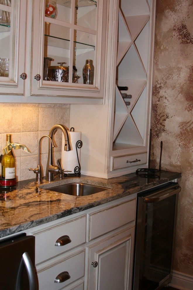 Foto de cocina clásica grande con puertas de armario blancas, encimera de granito, salpicadero beige, electrodomésticos de acero inoxidable y dos o más islas
