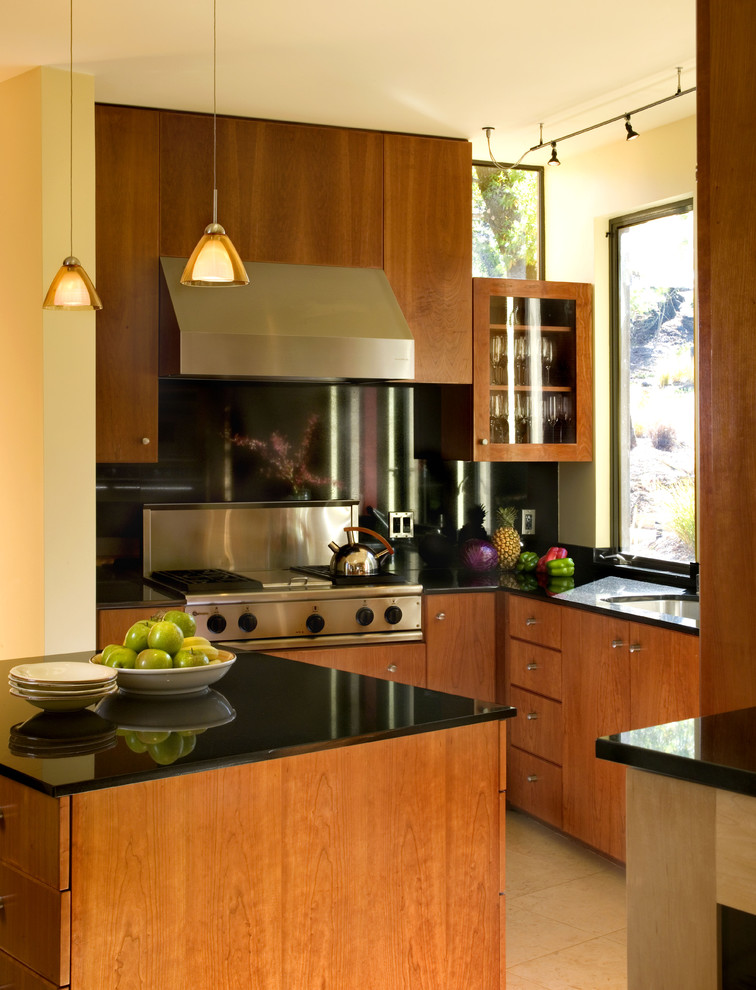 サンフランシスコにあるコンテンポラリースタイルのおしゃれなキッチン (フラットパネル扉のキャビネット、シルバーの調理設備、中間色木目調キャビネット、黒いキッチンパネル、石スラブのキッチンパネル) の写真