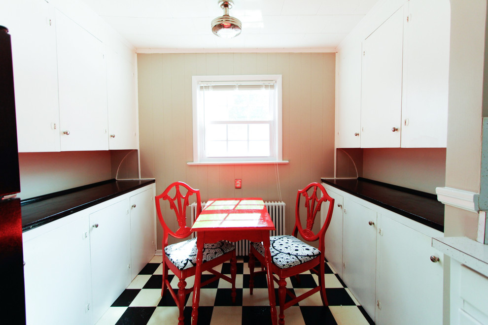 На фото: маленькая параллельная кухня в стиле фьюжн с обеденным столом, белыми фасадами и полом из линолеума для на участке и в саду