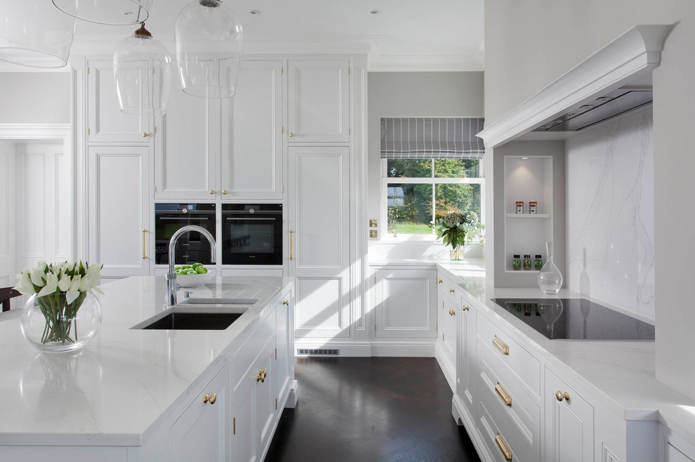 Elegant eat-in kitchen photo in Dublin with recessed-panel cabinets, white cabinets and an island