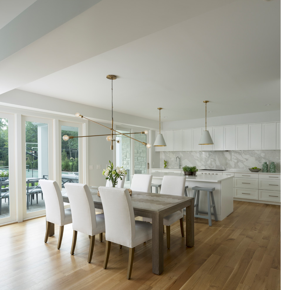 Example of a transitional light wood floor and beige floor eat-in kitchen design in Detroit with shaker cabinets, white cabinets, gray backsplash, stone slab backsplash, an island and white countertops