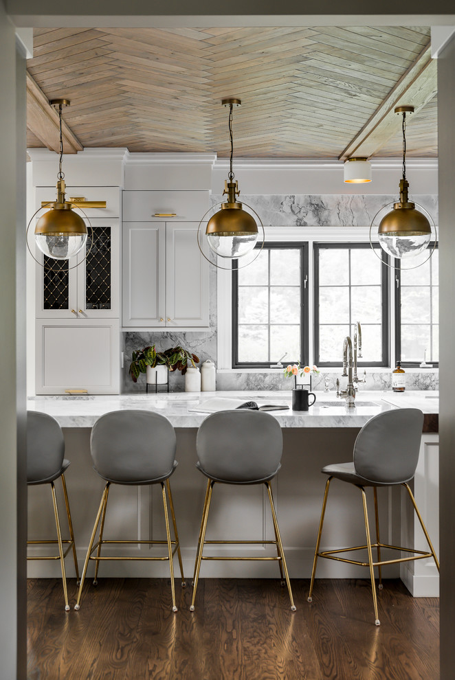 Enclosed kitchen - mid-sized transitional medium tone wood floor and brown floor enclosed kitchen idea in Chicago with a farmhouse sink, recessed-panel cabinets, gray cabinets, quartzite countertops, gray backsplash, stone slab backsplash, paneled appliances, an island and gray countertops