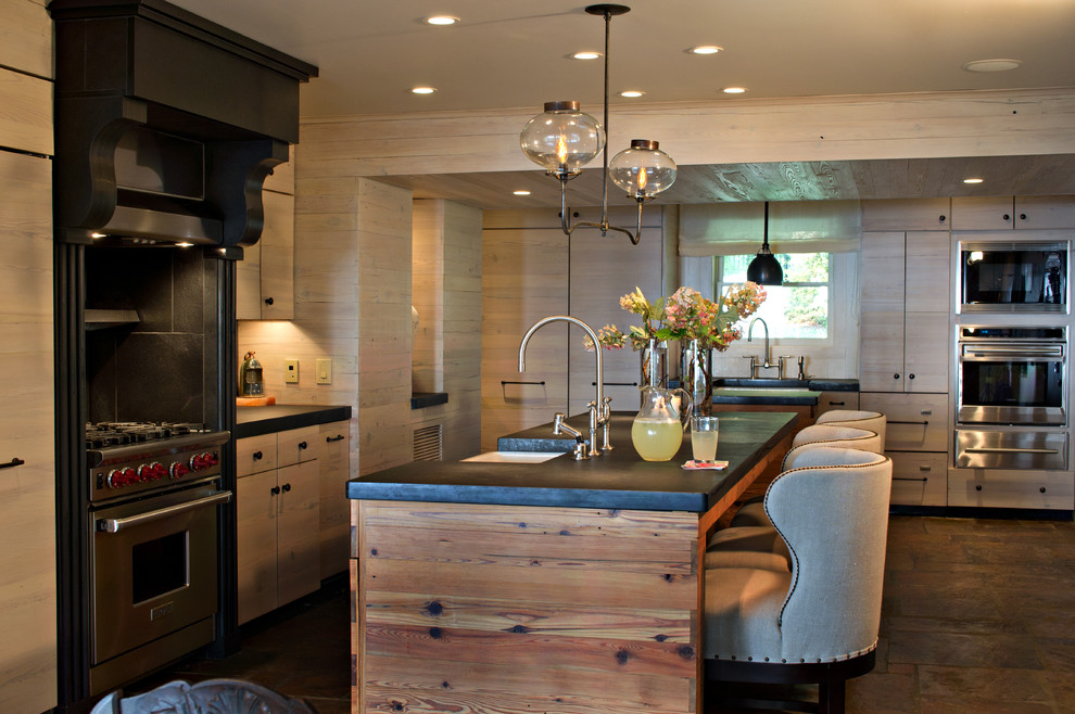 Rustikale Küche mit flächenbündigen Schrankfronten, Küchengeräten aus Edelstahl, hellen Holzschränken und Mauersteinen in Sonstige