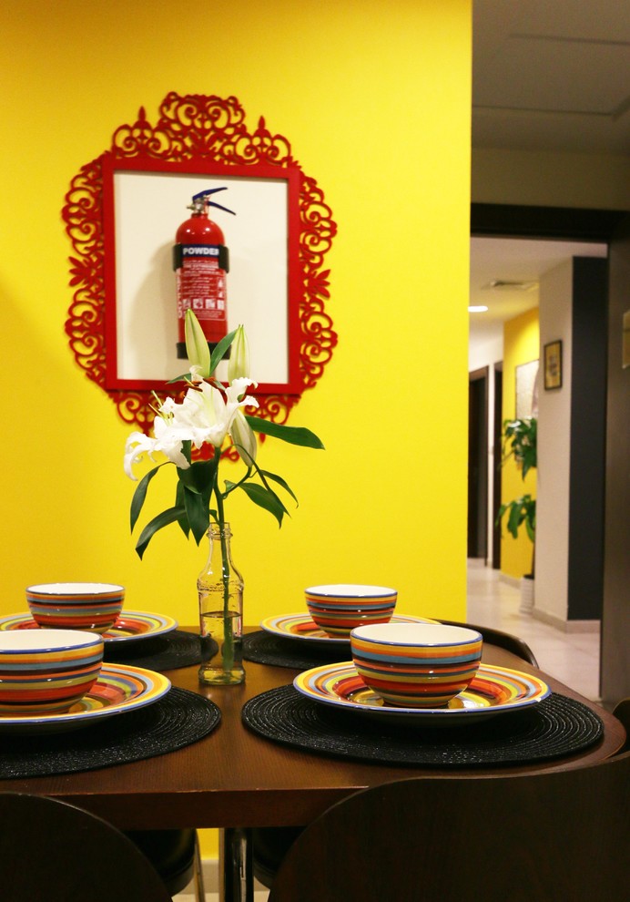 Foto de comedor bohemio grande con paredes amarillas y suelo de baldosas de porcelana