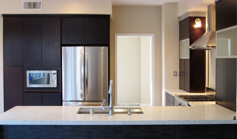 Exempel på ett modernt kök, med en undermonterad diskho, släta luckor, svarta skåp, bänkskiva i kvarts, vitt stänkskydd och rostfria vitvaror